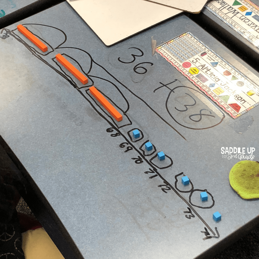 Using math manipulatives to solve addition and subtraction with regrouping